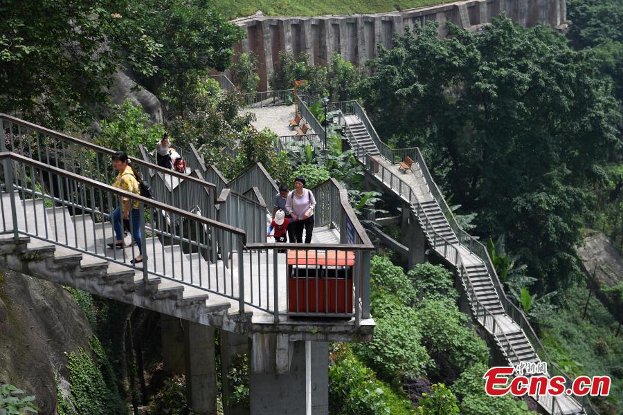 A view of a pathway built along a hilly slope leading to the entrance of a residential community in Yuzhong District, Southwest China’s Chongqing Municipality, May 22, 2019. The road is about one kilometre long, with a height of nearly 100 meters. Built on mountains, the city has been nicknamed a \
