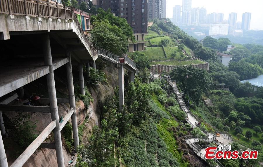 A view of a pathway built along a hilly slope leading to the entrance of a residential community in Yuzhong District, Southwest China’s Chongqing Municipality, May 22, 2019. The road is about one kilometre long, with a height of nearly 100 meters. Built on mountains, the city has been nicknamed a \