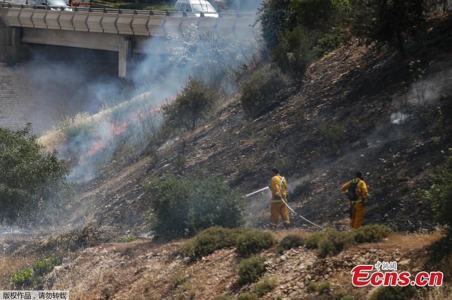 Firefighters extinguish a fire in a forest amidst extreme heat wave near the Israeli city of Modiin on May 23, 2019. (Photo/Agencies)