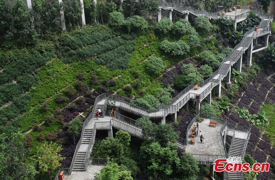 A view of a pathway built along a hilly slope leading to the entrance of a residential community in Yuzhong District, Southwest China’s Chongqing Municipality, May 22, 2019. The road is about one kilometre long, with a height of nearly 100 meters. Built on mountains, the city has been nicknamed a \