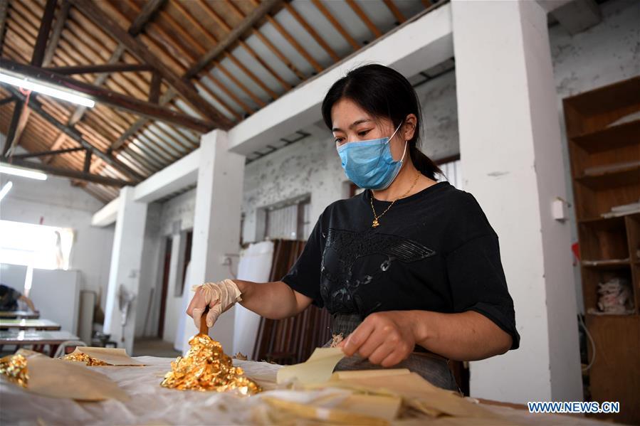 A worker prepares sheets of gold foil before grinding them into powder to make Fenlajian paper at a workshop run by paper artisan Liu Jing in Huanglu Township of Chaohu, east China\'s Anhui Province, May 23, 2019. Fenlajian is a high-end wax mineral paper which dates back to the Tang dynasty (618-907). For centuries, access to the Fenlajian paper had remained a privilege reserved solely for China\'s imperial families, due to the costly materials and the set of complicated procedures involved in its making. The techniques in producing this fine writing and painting material even became lost in the late Qing dynasty (1644-1911), until Liu Jing, an Anhui-based paper artisan, managed to revive them through constant trials by the end of the 20th century. Born in a family of paper-makers, Liu now runs a paper workshop dedicated to making Fenlajian and other classical papers while promoting their know-hows. Liu\'s classical paper processing techniques were listed as a national intangible cultural heritage in 2008, and he himself was named as a national representative inheritor to the aforementioned techniques in 2018. (Xinhua/Liu Junxi)