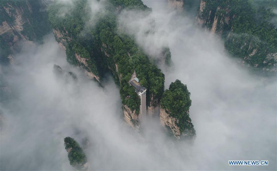 Aerial photo taken on May 25, 2019 shows the 326-meter-high Bailong Elevator, the world\'s highest outdoor elevator, shrouded by fog at the Wulingyuan Scenic Area in Zhangjiajie, central China\'s Hunan Province. (Xinhua/Wu Yongbing)