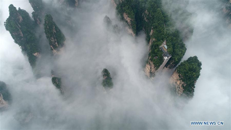 Aerial photo taken on May 25, 2019 shows the 326-meter-high Bailong Elevator, the world\'s highest outdoor elevator, shrouded by fog at the Wulingyuan Scenic Area in Zhangjiajie, central China\'s Hunan Province. (Xinhua/Wu Yongbing)