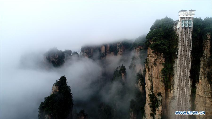 Aerial photo taken on May 25, 2019 shows the 326-meter-high Bailong Elevator, the world\'s highest outdoor elevator, shrouded by fog at the Wulingyuan Scenic Area in Zhangjiajie, central China\'s Hunan Province. (Xinhua/Wu Yongbing)