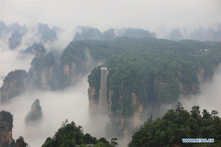 Aerial photo taken on May 25, 2019 shows the 326-meter-high Bailong Elevator, the world\'s highest outdoor elevator, shrouded by fog at the Wulingyuan Scenic Area in Zhangjiajie, central China\'s Hunan Province. (Xinhua/Wu Yongbing)