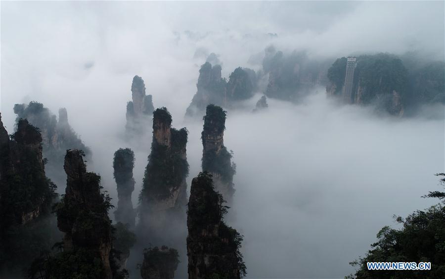 Aerial photo taken on May 25, 2019 shows the 326-meter-high Bailong Elevator, the world\'s highest outdoor elevator, shrouded by fog at the Wulingyuan Scenic Area in Zhangjiajie, central China\'s Hunan Province. (Xinhua/Wu Yongbing)
