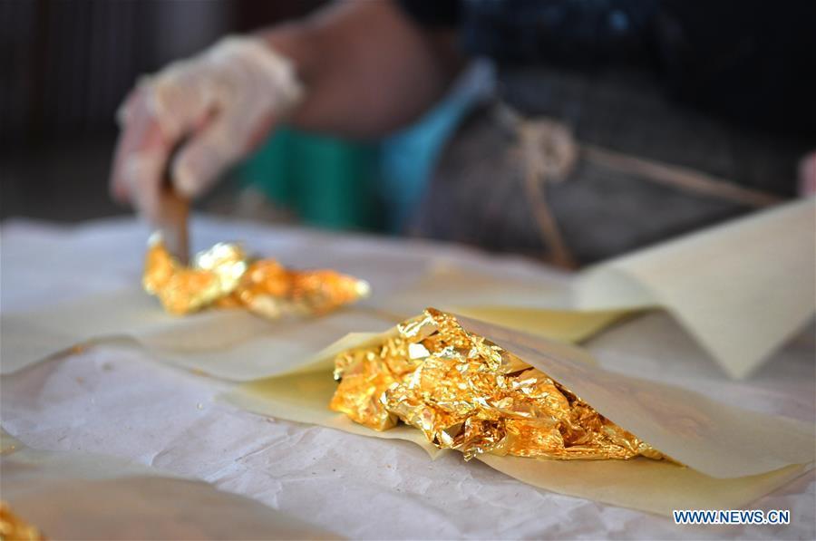 A worker prepares sheets of gold foil before grinding them into powder to make Fenlajian paper at a workshop run by paper artisan Liu Jing in Huanglu Township of Chaohu, east China\'s Anhui Province, May 23, 2019. Fenlajian is a high-end wax mineral paper which dates back to the Tang dynasty (618-907). For centuries, access to the Fenlajian paper had remained a privilege reserved solely for China\'s imperial families, due to the costly materials and the set of complicated procedures involved in its making. The techniques in producing this fine writing and painting material even became lost in the late Qing dynasty (1644-1911), until Liu Jing, an Anhui-based paper artisan, managed to revive them through constant trials by the end of the 20th century. Born in a family of paper-makers, Liu now runs a paper workshop dedicated to making Fenlajian and other classical papers while promoting their know-hows. Liu\'s classical paper processing techniques were listed as a national intangible cultural heritage in 2008, and he himself was named as a national representative inheritor to the aforementioned techniques in 2018. (Xinhua/Liu Junxi)