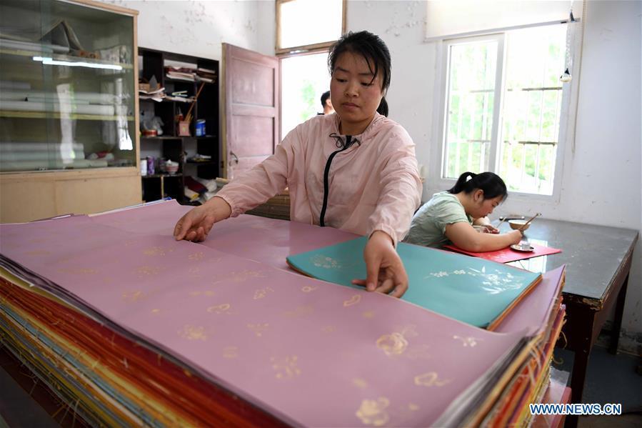 A worker examines half-finished Fenlajian paper at a workshop run by paper artisan Liu Jing in Huanglu Township of Chaohu, east China\'s Anhui Province, May 23, 2019. Fenlajian is a high-end wax mineral paper which dates back to the Tang dynasty (618-907). For centuries, access to the Fenlajian paper had remained a privilege reserved solely for China\'s imperial families, due to the costly materials and the set of complicated procedures involved in its making. The techniques in producing this fine writing and painting material even became lost in the late Qing dynasty (1644-1911), until Liu Jing, an Anhui-based paper artisan, managed to revive them through constant trials by the end of the 20th century. Born in a family of paper-makers, Liu now runs a paper workshop dedicated to making Fenlajian and other classical papers while promoting their know-hows. Liu\'s classical paper processing techniques were listed as a national intangible cultural heritage in 2008, and he himself was named as a national representative inheritor to the aforementioned techniques in 2018. (Xinhua/Liu Junxi)