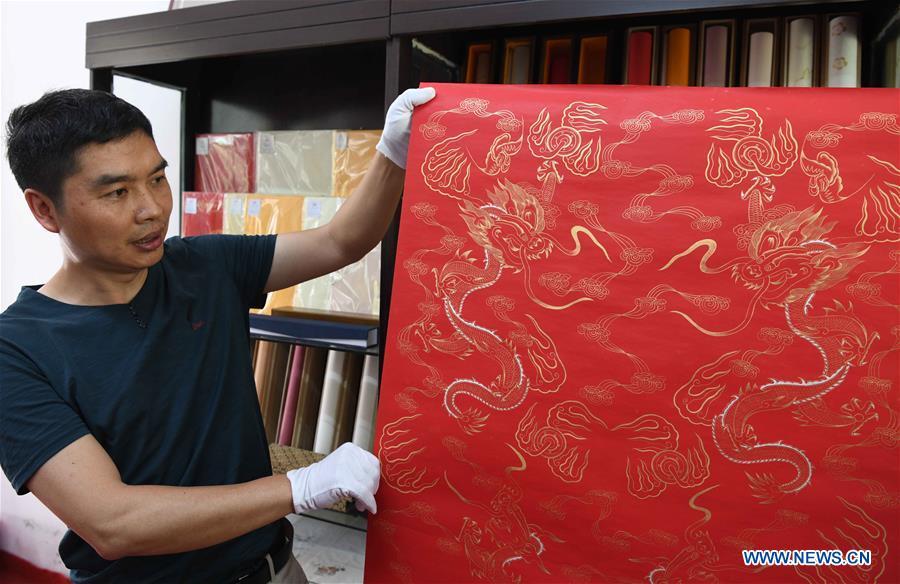 Paper artisan Liu Jing shows a piece of Fenlajian paper at his workshop in Huanglu Township of Chaohu, east China\'s Anhui Province, May 23, 2019. Fenlajian is a high-end wax mineral paper which dates back to the Tang dynasty (618-907). For centuries, access to the Fenlajian paper had remained a privilege reserved solely for China\'s imperial families, due to the costly materials and the set of complicated procedures involved in its making. The techniques in producing this fine writing and painting material even became lost in the late Qing dynasty (1644-1911), until Liu Jing, an Anhui-based paper artisan, managed to revive them through constant trials by the end of the 20th century. Born in a family of paper-makers, Liu now runs a paper workshop dedicated to making Fenlajian and other classical papers while promoting their know-hows. Liu\'s classical paper processing techniques were listed as a national intangible cultural heritage in 2008, and he himself was named as a national representative inheritor to the aforementioned techniques in 2018. (Xinhua/Liu Junxi)