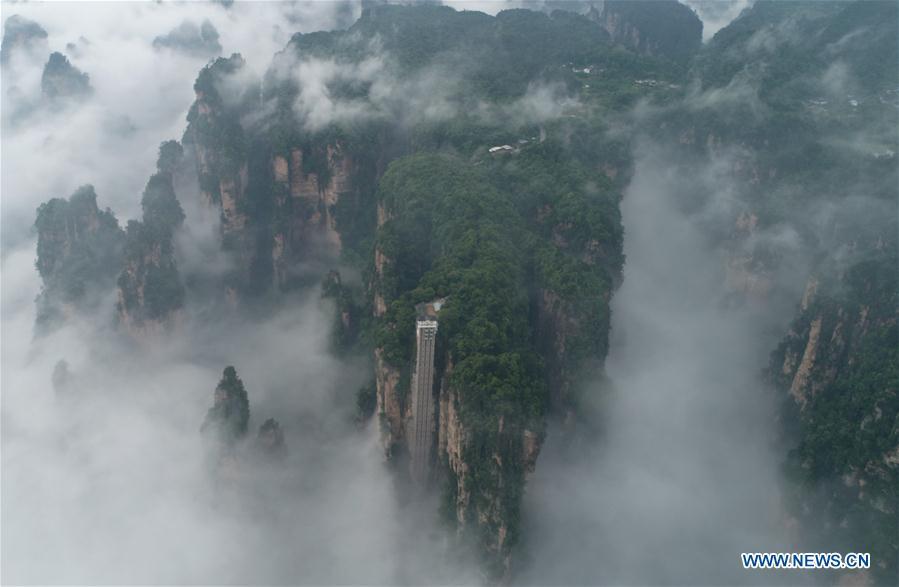 Aerial photo taken on May 25, 2019 shows the 326-meter-high Bailong Elevator, the world\'s highest outdoor elevator, shrouded by fog at the Wulingyuan Scenic Area in Zhangjiajie, central China\'s Hunan Province. (Xinhua/Wu Yongbing)