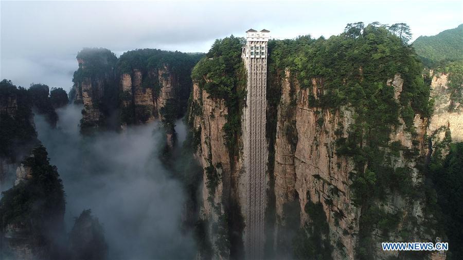Aerial photo taken on May 25, 2019 shows the 326-meter-high Bailong Elevator, the world\'s highest outdoor elevator, shrouded by fog at the Wulingyuan Scenic Area in Zhangjiajie, central China\'s Hunan Province. (Xinhua/Wu Yongbing)