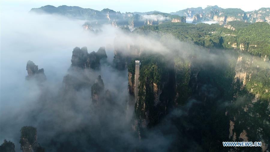 Aerial photo taken on May 25, 2019 shows the 326-meter-high Bailong Elevator, the world\'s highest outdoor elevator, shrouded by fog at the Wulingyuan Scenic Area in Zhangjiajie, central China\'s Hunan Province. (Xinhua/Wu Yongbing)