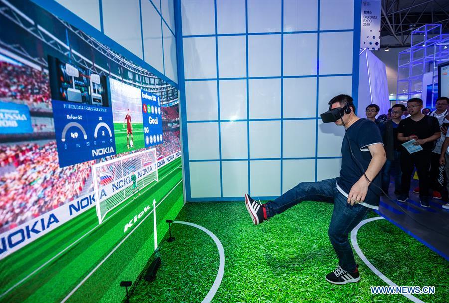A visitor plays a football game during China International Big Data Industry Expo 2019 in Guiyang, southwest China\'s Guizhou Province, May 26, 2019. The expo on big data opened Sunday in Guizhou Province, focusing on the latest innovation of the technology and its applications. The four-day expo will be attended by 448 enterprises from 59 countries and regions, according to the organizing committee. (Xinhua/Tao Liang)