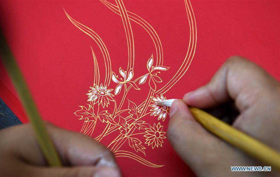 A worker applies gold paint to a piece of Fenlajian paper at a workshop run by paper artisan Liu Jing in Huanglu Township of Chaohu, east China\'s Anhui Province, May 23, 2019. Fenlajian is a high-end wax mineral paper which dates back to the Tang dynasty (618-907). For centuries, access to the Fenlajian paper had remained a privilege reserved solely for China\'s imperial families, due to the costly materials and the set of complicated procedures involved in its making. The techniques in producing this fine writing and painting material even became lost in the late Qing dynasty (1644-1911), until Liu Jing, an Anhui-based paper artisan, managed to revive them through constant trials by the end of the 20th century. Born in a family of paper-makers, Liu now runs a paper workshop dedicated to making Fenlajian and other classical papers while promoting their know-hows. Liu\'s classical paper processing techniques were listed as a national intangible cultural heritage in 2008, and he himself was named as a national representative inheritor to the aforementioned techniques in 2018. (Xinhua/Liu Junxi)