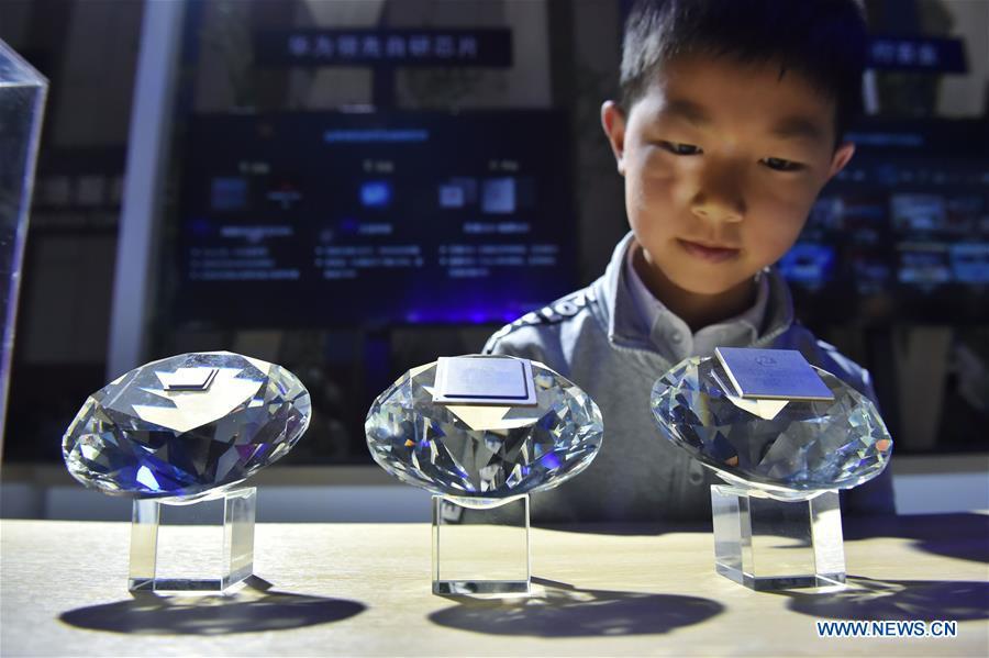 A kid views chips designed for 5G base stations by Huawei during China International Big Data Industry Expo 2019 in Guiyang, southwest China\'s Guizhou Province, May 26, 2019. The expo on big data opened Sunday in Guizhou Province, focusing on the latest innovation of the technology and its applications. The four-day expo will be attended by 448 enterprises from 59 countries and regions, according to the organizing committee. (Xinhua/Ou Dongqu)