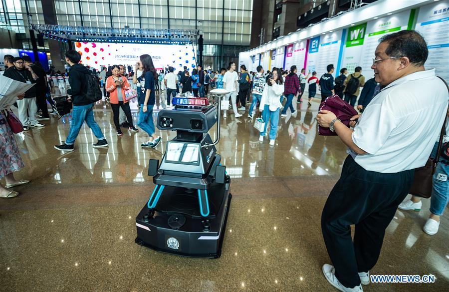 A visitor views an intelligent patrol guard during China International Big Data Industry Expo 2019 in Guiyang, southwest China\'s Guizhou Province, May 26, 2019. The expo on big data opened Sunday in Guizhou Province, focusing on the latest innovation of the technology and its applications. The four-day expo will be attended by 448 enterprises from 59 countries and regions, according to the organizing committee. (Xinhua/Tao Liang)