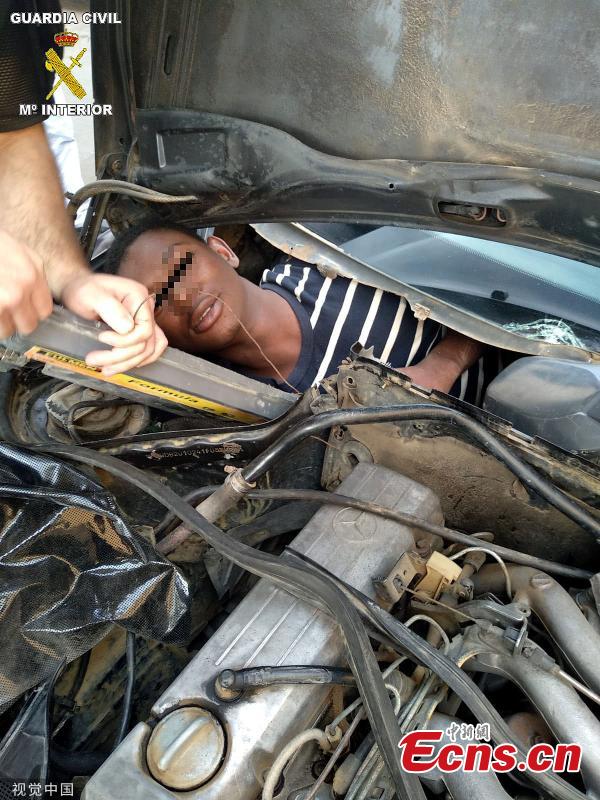 A picture shows a man in his twenties hiding behind the car\'s dashboard at the border in Beni-Enzar, Morocco. The refugee travelling from Morocco was found cramped into a car glove box attempting to travel to Europe. The car was stopped by border police whilst trying to enter Spain’s North African enclave of Melilla. Spanish Guard officers said three vehicles carrying stowaways were stopped in the space of three hours and found a total of four Moroccan migrants hidden in four vehicles. (Photo/VCG)