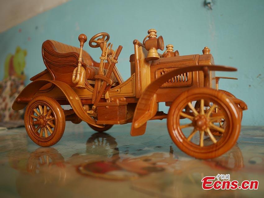 Chuai Mege shows his hand-made miniature motorcycles carved out of wood in Jilin City, Jilin Province. A former automobile mechanic, the 66-year-old man has been fascinated with making miniature motorcycles for 24 years. He said he usually needs a whole year to complete the making a miniature motorcycle because of his attention to detail and quality. For example, he needs to carve over 700 motorcycle parts including  tires, the dashboard, and even screws. (Photo: China News Service/Cang Yan)