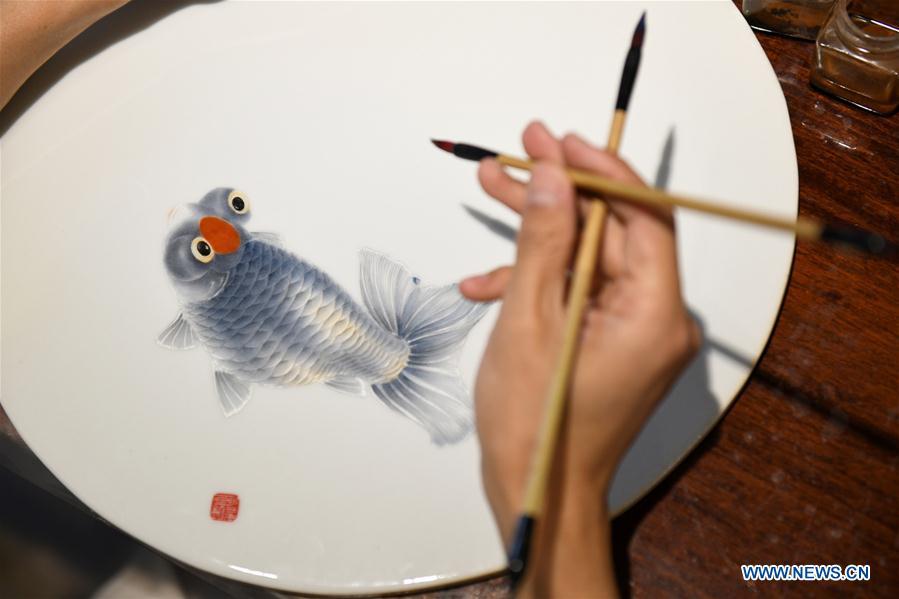 Ceramic painter Yang Yuhui paints in a studio in Shijiazhuang City, north China\'s Hebei province, May 27, 2019. (Xinhua/Xu Jianyuan)