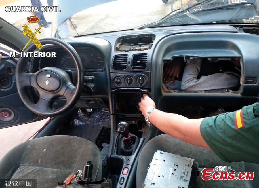A picture shows a man in his twenties hiding behind the car\'s dashboard at the border in Beni-Enzar, Morocco. The refugee travelling from Morocco was found cramped into a car glove box attempting to travel to Europe. The car was stopped by border police whilst trying to enter Spain’s North African enclave of Melilla. Spanish Guard officers said three vehicles carrying stowaways were stopped in the space of three hours and found a total of four Moroccan migrants hidden in four vehicles. (Photo/VCG)