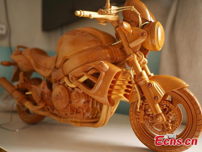 Chuai Mege shows his hand-made miniature motorcycles carved out of wood in Jilin City, Jilin Province. A former automobile mechanic, the 66-year-old man has been fascinated with making miniature motorcycles for 24 years. He said he usually needs a whole year to complete the making a miniature motorcycle because of his attention to detail and quality. For example, he needs to carve over 700 motorcycle parts including  tires, the dashboard, and even screws. (Photo: China News Service/Cang Yan)