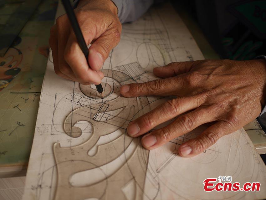 Chuai Mege shows his hand-made miniature motorcycles carved out of wood in Jilin City, Jilin Province. A former automobile mechanic, the 66-year-old man has been fascinated with making miniature motorcycles for 24 years. He said he usually needs a whole year to complete the making a miniature motorcycle because of his attention to detail and quality. For example, he needs to carve over 700 motorcycle parts including  tires, the dashboard, and even screws. (Photo: China News Service/Cang Yan)