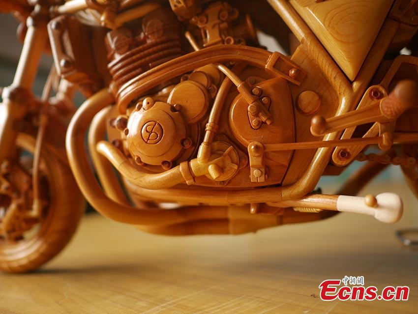 Chuai Mege shows his hand-made miniature motorcycles carved out of wood in Jilin City, Jilin Province. A former automobile mechanic, the 66-year-old man has been fascinated with making miniature motorcycles for 24 years. He said he usually needs a whole year to complete the making a miniature motorcycle because of his attention to detail and quality. For example, he needs to carve over 700 motorcycle parts including  tires, the dashboard, and even screws. (Photo: China News Service/Cang Yan)