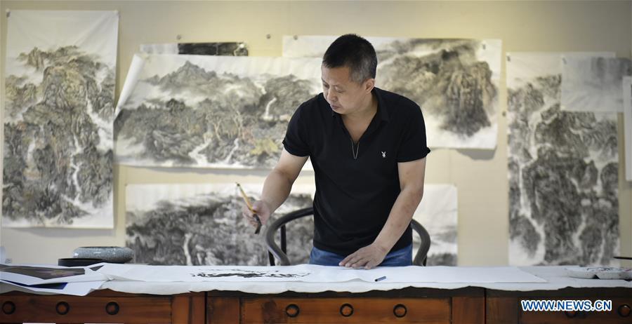 Chen Dongming paints a wood-block painting at his studio in Huanren County of Benxi, northeast China\'s Liaoning Province, May 27, 2019. Chen Dongming, a 52-year-old wood-block painter from Wafang Village of Huanren County in Benxi, learned the techniques from his grandfather since young. As an inheritor of Huanren wood-block painting, a provincial intangible cultural heritage in Liaoning, Chen has been committed to making a proper integration of traditional Chinese landscape paintings and wood-block New Year paintings to promote the craft in an innovative way. (Xinhua/Yao Jianfeng)