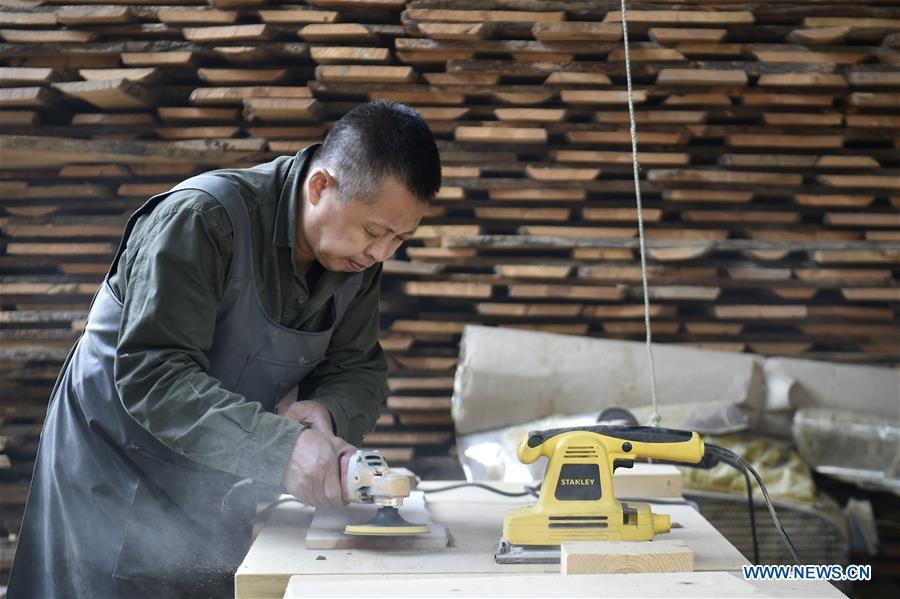 Chen Dongming polishes wood to make wood-block paintings at a factory in Huanren County of Benxi, northeast China\'s Liaoning Province, May 27, 2019. Chen Dongming, a 52-year-old wood-block painter from Wafang Village of Huanren County in Benxi, learned the techniques from his grandfather since young. As an inheritor of Huanren wood-block painting, a provincial intangible cultural heritage in Liaoning, Chen has been committed to making a proper integration of traditional Chinese landscape paintings and wood-block New Year paintings to promote the craft in an innovative way. (Xinhua/Yao Jianfeng)