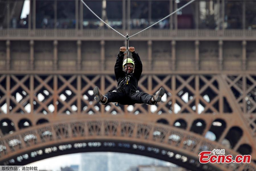 A participant rides a zip line from the second floor of the Eiffel Tower, 115 metres above the ground along an 800-metre long route, as part of the Smash Perrier free event operating until June 2 in Paris, France, May 28, 2019. (Photo/Agencies)