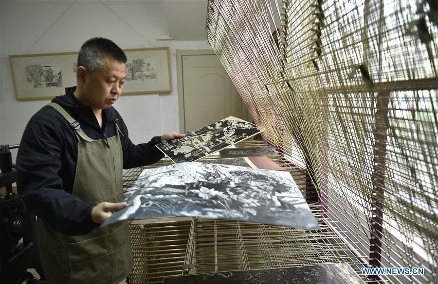 Chen Dongming airs wood-block paintings at his studio in Huanren County of Benxi, northeast China\'s Liaoning Province, May 27, 2019. Chen Dongming, a 52-year-old wood-block painter from Wafang Village of Huanren County in Benxi, learned the techniques from his grandfather since young. As an inheritor of Huanren wood-block painting, a provincial intangible cultural heritage in Liaoning, Chen has been committed to making a proper integration of traditional Chinese landscape paintings and wood-block New Year paintings to promote the craft in an innovative way. (Xinhua/Yao Jianfeng)