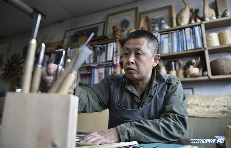 Chen Dongming chooses tools to make a wood-block painting at his studio in Huanren County of Benxi, northeast China\'s Liaoning Province, May 27, 2019. Chen Dongming, a 52-year-old wood-block painter from Wafang Village of Huanren County in Benxi, learned the techniques from his grandfather since young. As an inheritor of Huanren wood-block painting, a provincial intangible cultural heritage in Liaoning, Chen has been committed to making a proper integration of traditional Chinese landscape paintings and wood-block New Year paintings to promote the craft in an innovative way. (Xinhua/Yao Jianfeng)