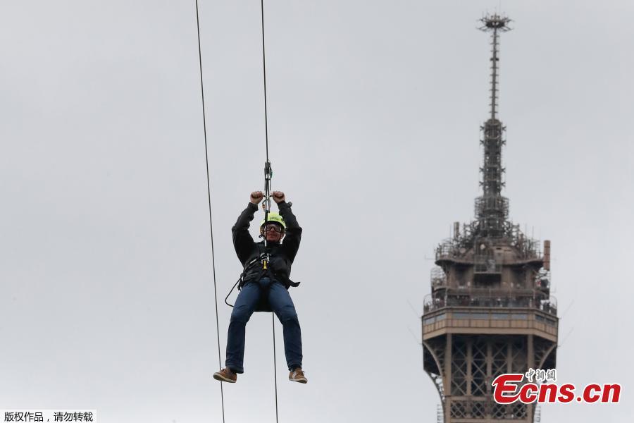 A person rides on a zip-line descending from the second floor of the Eiffel Tower on May 28, 2019 in Paris. The 800 meter crossing takes one minute at a speed of 90km/h. The zip-line will be opened from May 29 to June 2, 2019. (Photo/Agencies)