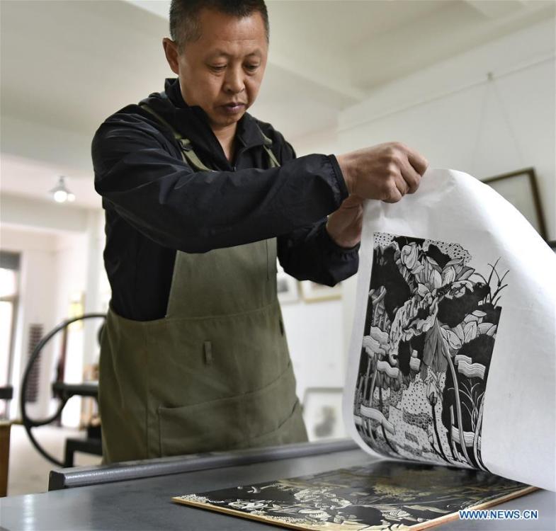 Chen Dongming works on a wood-block painting at his studio in Huanren County of Benxi, northeast China\'s Liaoning Province, May 27, 2019. Chen Dongming, a 52-year-old wood-block painter from Wafang Village of Huanren County in Benxi, learned the techniques from his grandfather since young. As an inheritor of Huanren wood-block painting, a provincial intangible cultural heritage in Liaoning, Chen has been committed to making a proper integration of traditional Chinese landscape paintings and wood-block New Year paintings to promote the craft in an innovative way. (Xinhua/Yao Jianfeng)