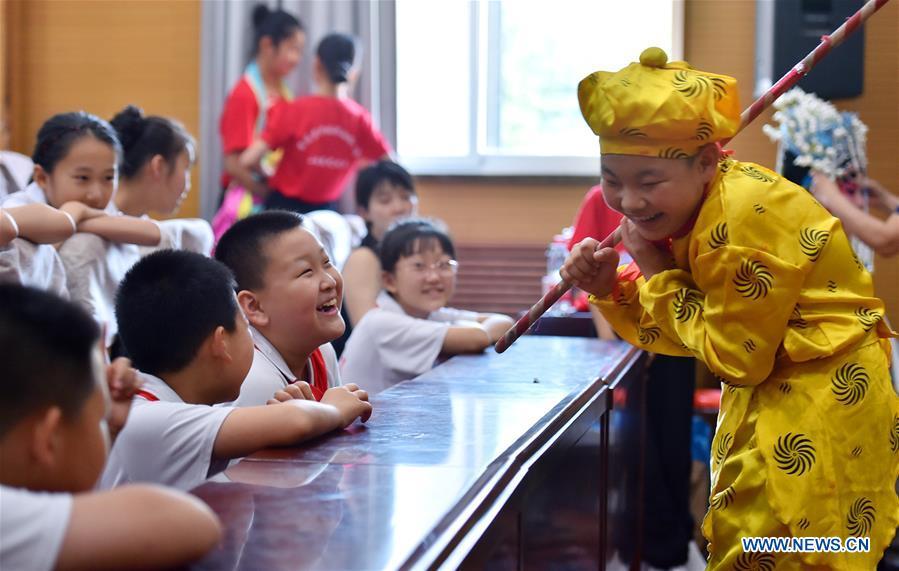 Students interact with each other during the break of a Peking Opera show in celebration of the upcoming International Children\'s Day at a primary school in Shijiazhuang City, north China\'s Hebei Province, May 29, 2019. (Xinhua/Zhang Xiaofeng)