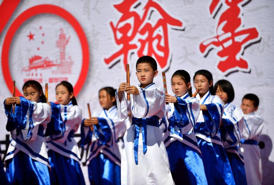 Primary school students wearing traditional Han Chinese attend a ceremony during a calligraphy competition in Yinchuan, capital of Northwest China\'s Ningxia Hui autonomous region, on Tuesday.  (Photo by Li Jing/for chinadaily.com.cn)
