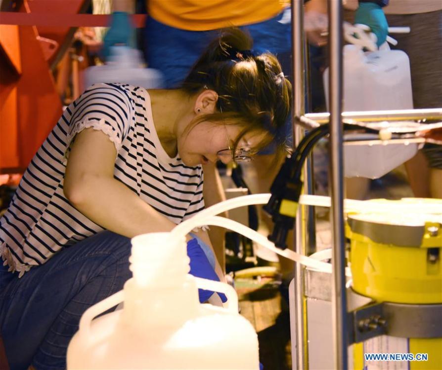 A researcher collects samples of sea water from the CTD(Conductivity Temperature Depth) on China\'s research vessel KEXUE(Science) in the western Pacific Ocean, May 29, 2019. KEXUE is carrying out a 20-day long investigation over a series of seamounts in the south of the Mariana Trench in the western Pacific Ocean. They will focus on biological diversities, ecological systems and biological distributions of the seamounts that they planned to explore. (Xinhua/Zhang Xudong)