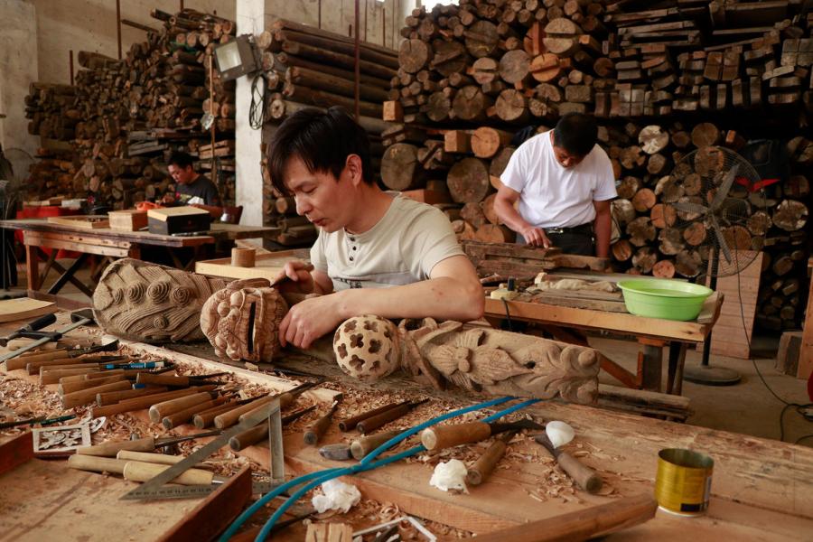 Craftsmen repair wooden components of ancient residences in the warehouse of Bengbu Ancient Residence Exhibition Park, based in Bengbu city of East China\'s Anhui province. （By Zhu Lixin/chinadaily.com.cn）