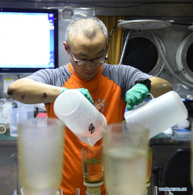 A researcher deals with samples of sea water on China\'s research vessel KEXUE (Science) in the western Pacific Ocean, May 29, 2019. KEXUE is carrying out a 20-day long investigation over a series of seamounts in the south of the Mariana Trench in the western Pacific Ocean. They will focus on biological diversities, ecological systems and biological distributions of the seamounts that they planned to explore. (Xinhua/Zhang Xudong)