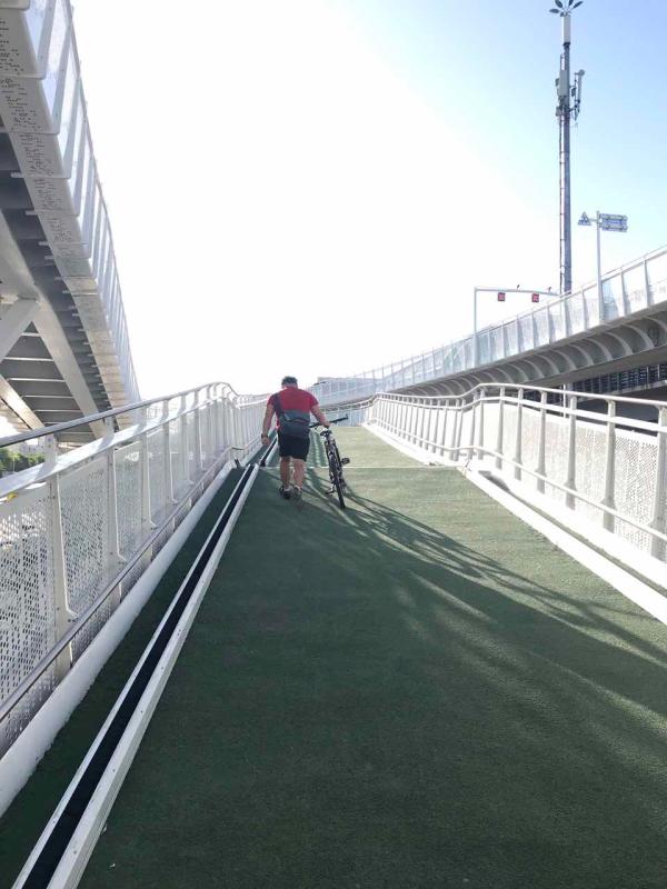 A cyclist walks with his bike up the slope on the first bicycle-only lane in Beijing, May 31, 2019.  (Photo/chinadaily.com.cn)