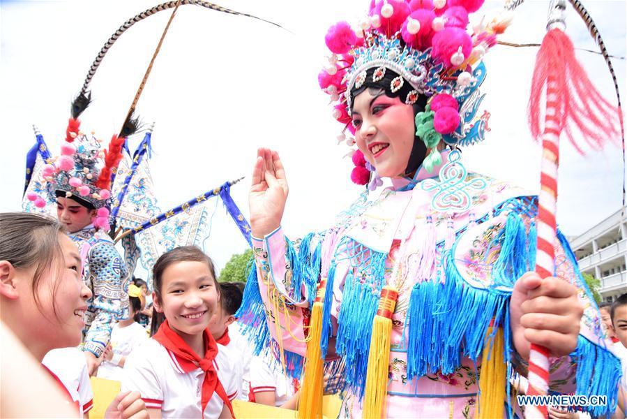 A young Wu Opera actress interacts with students during an event in celebration of the International Children\'s Day in Jiande City, east China\'s Zhejiang Province, May 30, 2019. (Xinhua/Ning Wenwu)