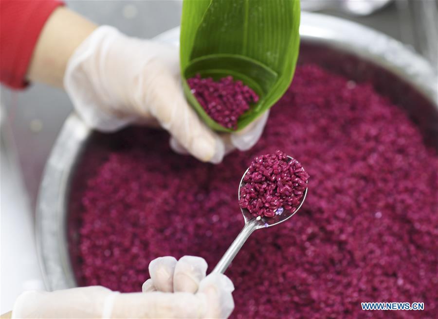 A worker makes colorful Zongzi, pyramid-shaped dumplings made of glutinous rice wrapped in bamboo or reed leaves, at a factory in Taijiang County, southwest China\'s Guizhou Province, June 2, 2019. Different plant juices are used to color the glutinous rice when making the colorful Zongzi. Zongzi is a traditional food for the Dragon Boat Festival, which falls on June 7 this year. (Xinhua/Liu Kaifu)