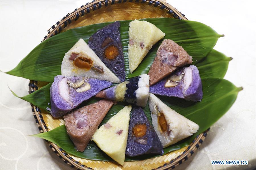 Photo taken on June 2, 2019 shows colorful Zongzi, pyramid-shaped dumplings made of glutinous rice wrapped in bamboo or reed leaves, at a factory in Taijiang County, southwest China\'s Guizhou Province. Different plant juices are used to color the glutinous rice when making the colorful Zongzi. Zongzi is a traditional food for the Dragon Boat Festival, which falls on June 7 this year. (Xinhua/Liu Kaifu)
