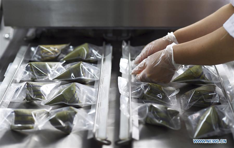 A worker packs colorful Zongzi, pyramid-shaped dumplings made of glutinous rice wrapped in bamboo or reed leaves, at a factory in Taijiang County, southwest China\'s Guizhou Province, June 2, 2019. Different plant juices are used to color the glutinous rice when making the colorful Zongzi. Zongzi is a traditional food for the Dragon Boat Festival, which falls on June 7 this year. (Xinhua/Liu Kaifu)