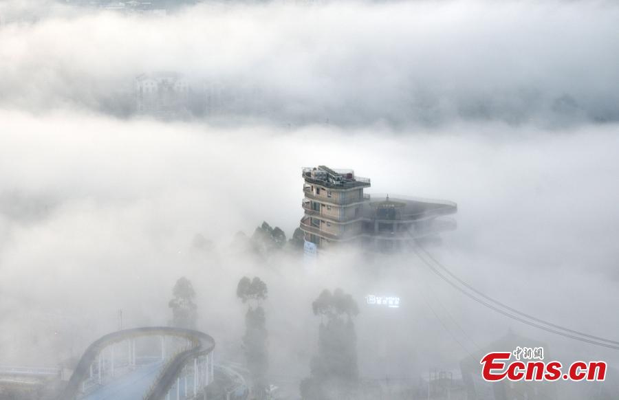 Fog shrouds buildings in the Wine Town, near the Yangtze River, in Fuling District, Chongqing Municipality, June 2, 2019. (Photo: China News Service/Shi Wei)