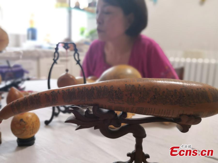 Craftswoman Chen Bing shows gourds she carved in Lanzhou City, Gansu Province in June 2019.  The second generation in her family to make artistic creations on gourds, she carved  characters sometimes just one millimeter in size. (Photo: China News Service/Yang Na)