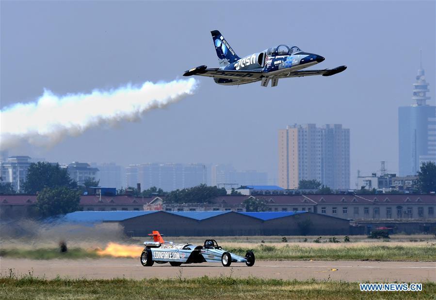 An enthusiast flying a small plane competes for speed with a racer during the opening of the 11th Air Sports Culture and Tourism Festival in Anyang, central China\'s Henan Province, June 3, 2019. The event kicked off Monday in the city of Anyang, attracting air sports fans from home and abroad. (Xinhua/Li An)