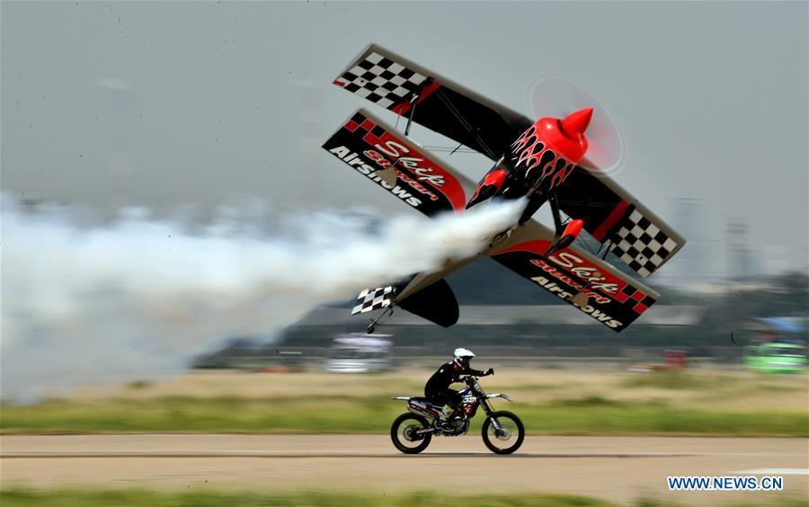 An enthusiast flying a small plane races with a motorcycle during the opening of the 11th Air Sports Culture and Tourism Festival in Anyang, central China\'s Henan Province, June 3, 2019. The event kicked off Monday in the city of Anyang, attracting air sports fans from home and abroad. (Xinhua/Li Jianan)