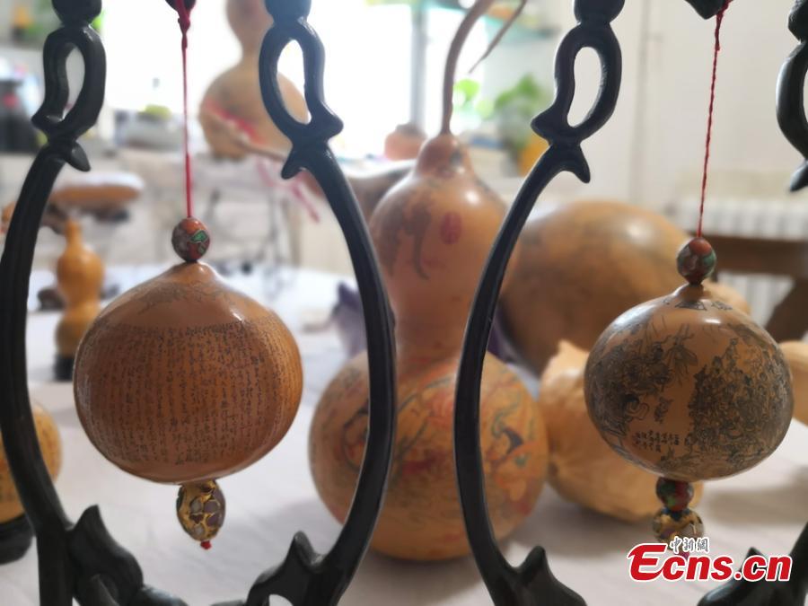 Craftswoman Chen Bing shows gourds she carved in Lanzhou City, Gansu Province in June 2019.  The second generation in her family to make artistic creations on gourds, she carved  characters sometimes just one millimeter in size. (Photo: China News Service/Yang Na)