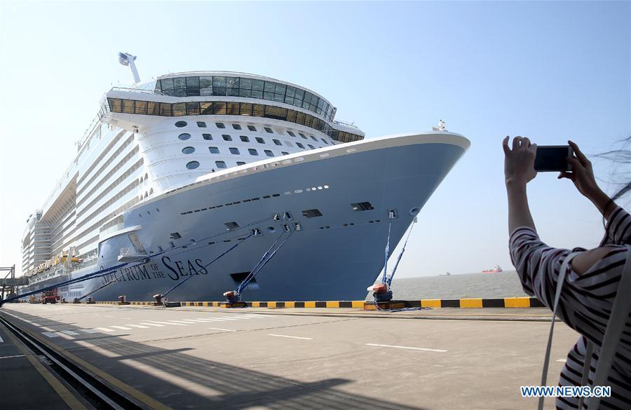 A tourist takes photos of the Royal Caribbean International cruise ship \